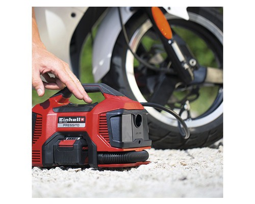 Akumulátorový kompresor Einhell Pressito 18 V Power X-Change s motocyklem v pozadí