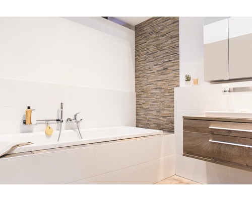 Světlá koupelna s vanou, umyvadlem a obklady stěn