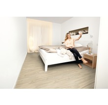 Světlá ložnice s dřevěnou podlahou, postelí, nočním stolkem a denním světlem