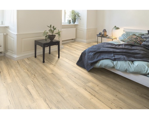 Světlá místnost s laminátovou podlahou se vzhledem dřeva, postelí a odkládacím stolkem