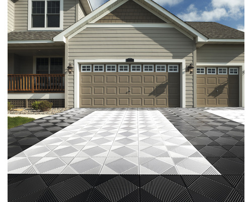 Příjezdová cesta s černými a světlými podlahovými dlaždicemi před domem s dvojitou garáží