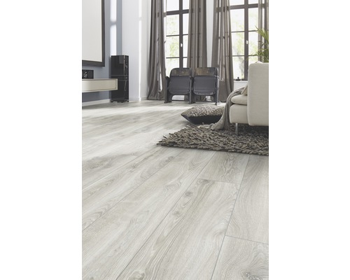 Světlý obývací pokoj s laminátovou podlahou se vzhledem dřeva, pohovkou a kobercem