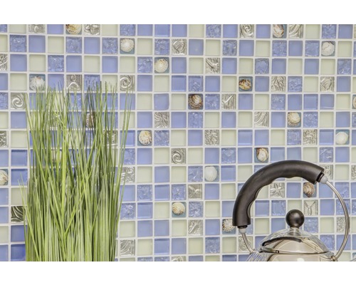 Mozaiková stěna s ornamenty mořských živočichů, umělá tráva a čajová konvice