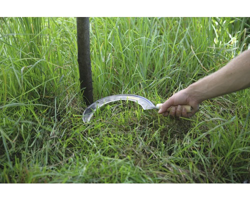 Ruční kosa s dřevěnou rukojetí seká trávu