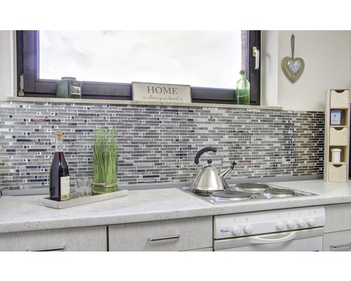 Kuchyňská scéna s mozaikovými obklady, varnou deskou, čajovou konvicí a dekoracemi