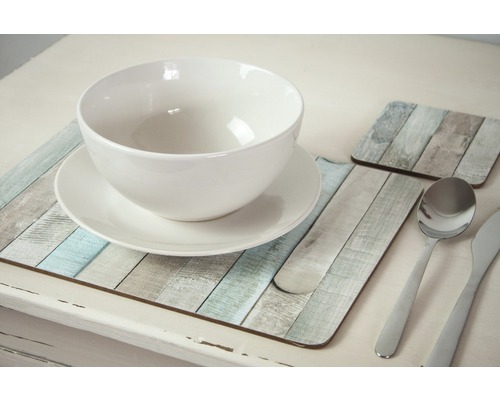 Prostřený stůl s bílou miskou, talířem, příbory a podložkami v designu dřeva