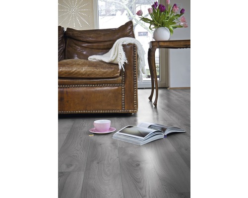 Obývací pokoj s šedou laminátovou podlahou, koženou sedačkou a dekorací