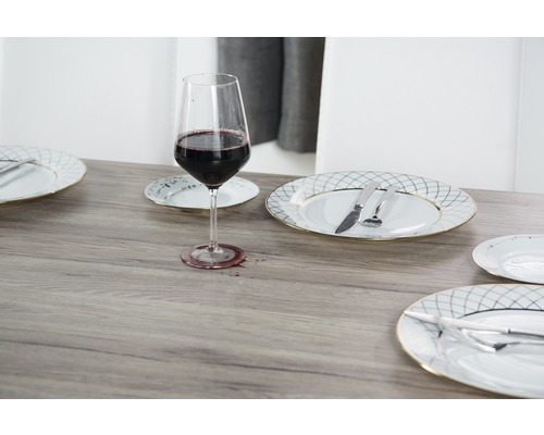 Prostřený stůl se sklenicí na víno, talíři a příbory