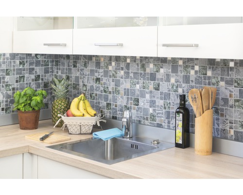 Světlá kuchyně s mozaikovými obklady, nerezovým dřezem a čerstvými surovinami.