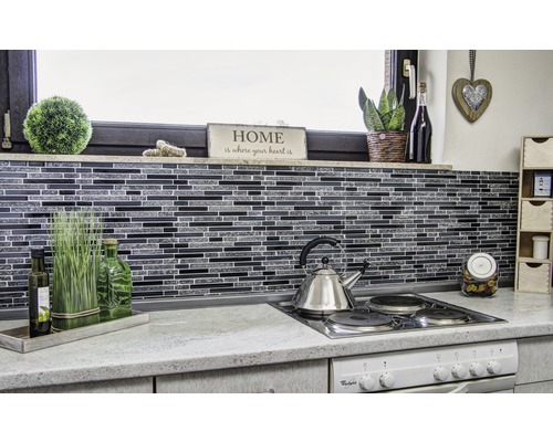 Kuchyňská scéna s mozaikovými obklady, nerezovou varnou konvicí a dekorativními prvky.