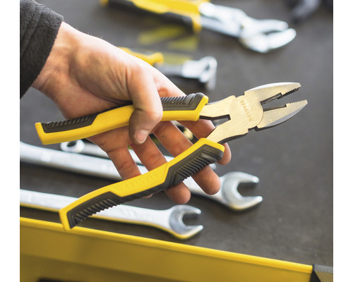 Kombinované kleště Stanley s žlutočernou rukojetí v ruce