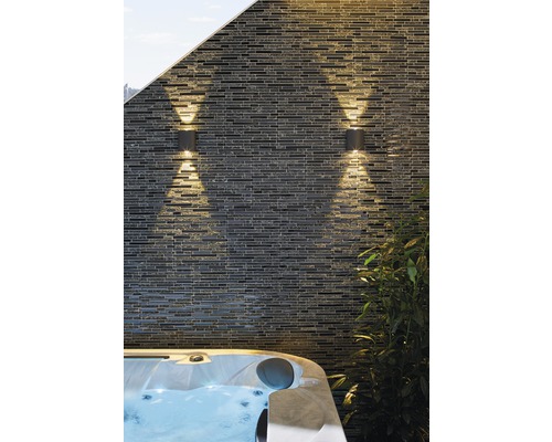 Dvě venkovní svítidla na kamenné zdi vedle vířivky