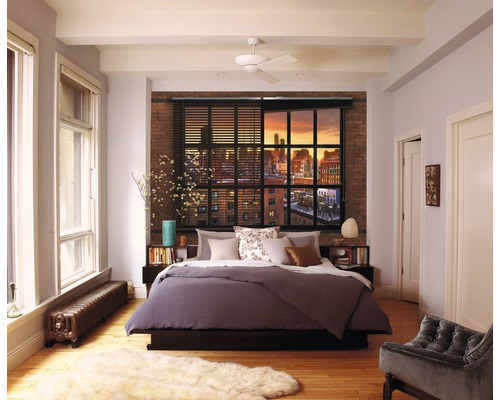 Ložnice s postelí, oknem a cihlovou zdí