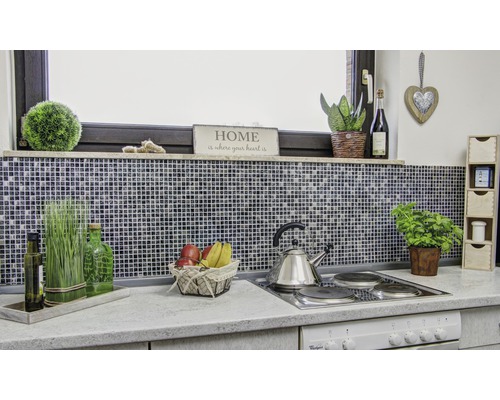 Kuchyňská scéna s mozaikovými obklady, dekoracemi a kuchyňským náčiním na pracovní desce