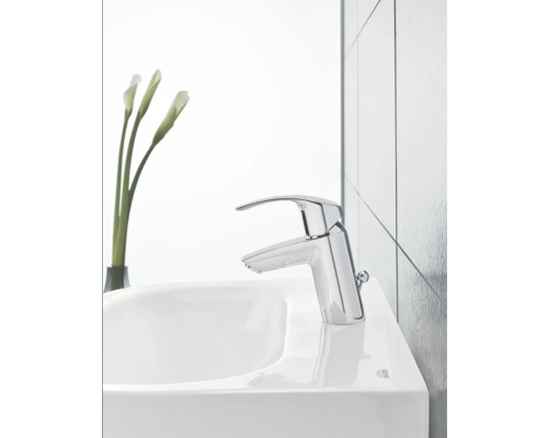 Umyvadlová baterie na umyvadle s vázou květin