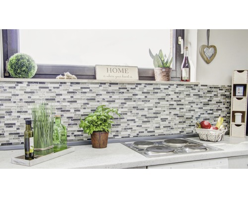 Kuchyňská scéna s mozaikovými obklady, bylinkami, dekoracemi a elektrickým sporákem