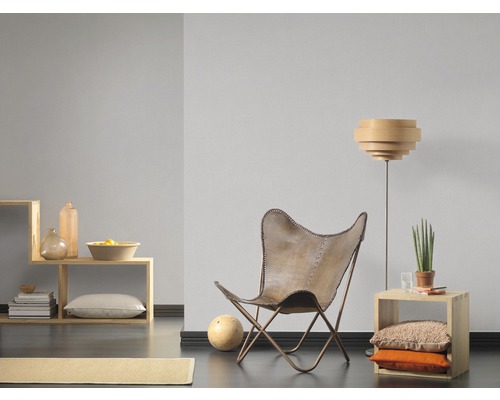 Obývací pokoj s křeslem, stojací lampou a dřevěnými regály