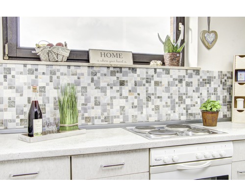 Kuchyňská scéna s mozaikovými obklady, sporákem a dekorativními prvky pro útulnou atmosféru.