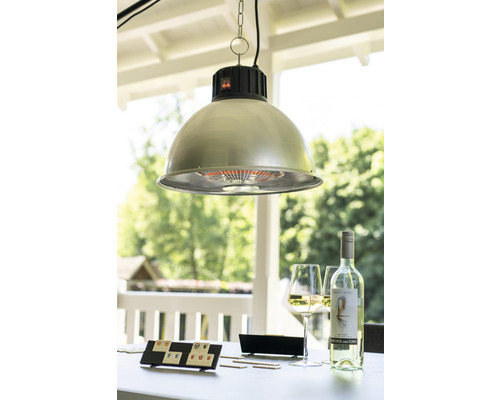 Venkovní scéna se závěsnou lampou, hrou, lahví vína a sklenicemi na stole