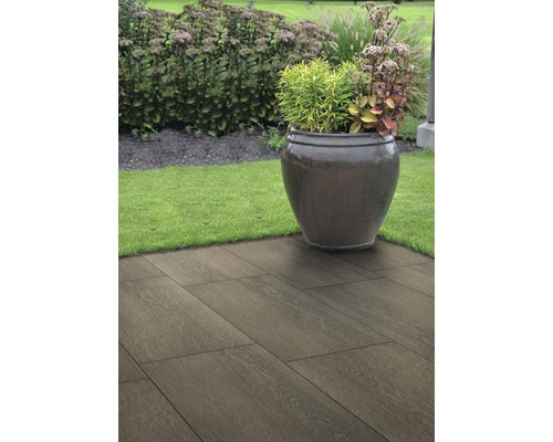 Zahradní krajina s keramickými dlaždicemi s dřevěným vzhledem a osázeným květináčem