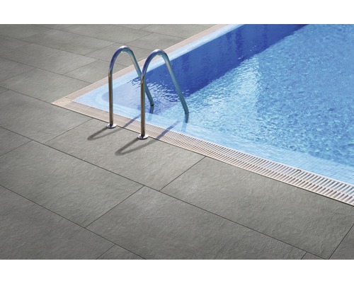 Bazén s šedými terasovými dlaždicemi a nerezovým žebříkem