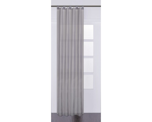Šedý závěs s poutky před oknem.