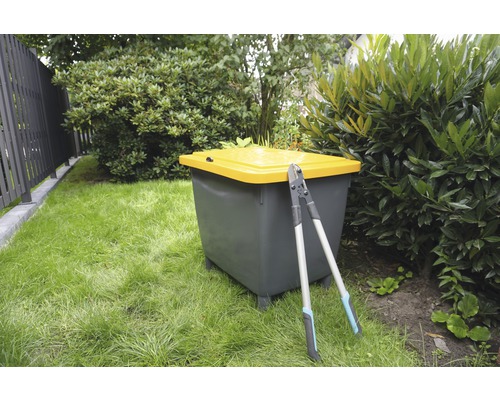 Zahradní scéna s kompostérem a zahradnickými nůžkami na trávníku