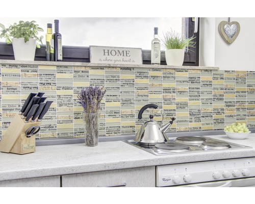 Kuchyňská scéna s mozaikovými obklady, noži, konvicí a dekoracemi na pracovní desce