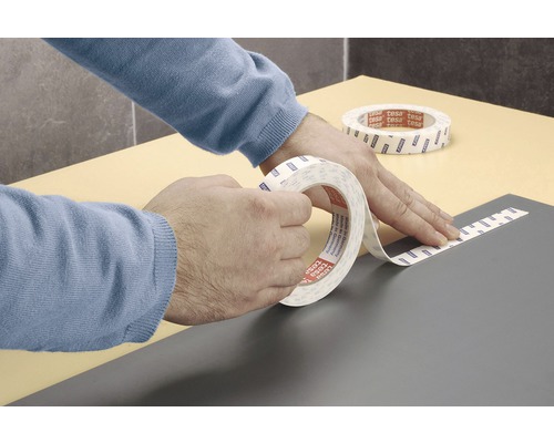 Uživatel aplikuje oboustrannou lepicí pásku Tesa na povrch