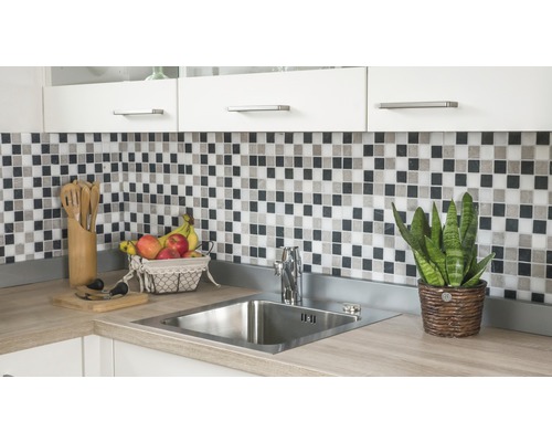 Kuchyňský dřez s baterií, mozaikové obklady a kuchyňské náčiní na kuchyňské lince