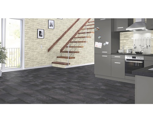 Světlá místnost s šedou kuchyní, schodištěm a tmavou dřevěnou podlahou.