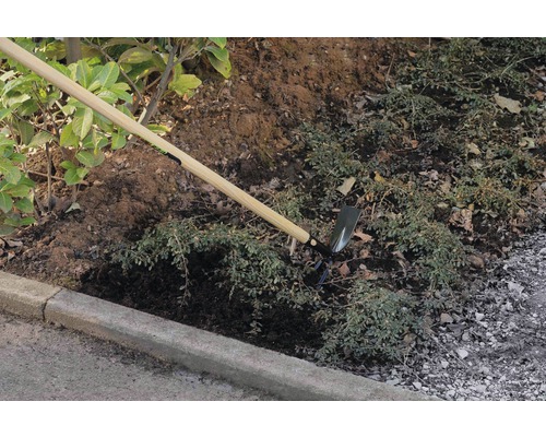 Zahradní motyka s dřevěnou násadou používaná k úpravě půdy