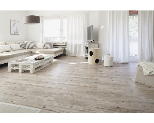 Světlý obývací pokoj s dřevěnou podlahou, pohovkou, stolem a denním světlem