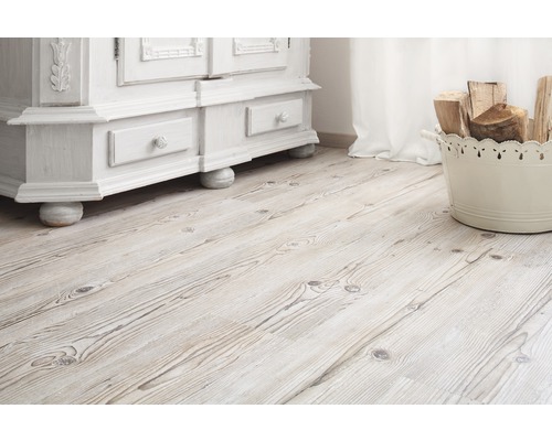 Světlá dřevěná podlaha s bílou skříní a košem s dřevem