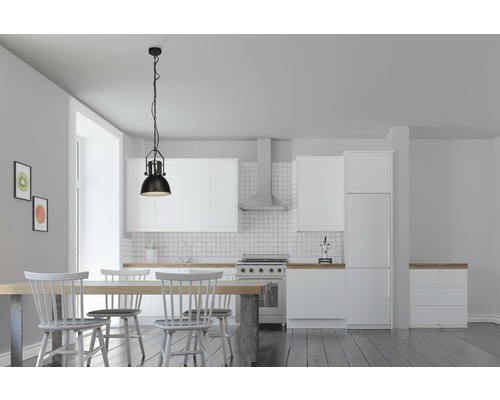 Jídelna s jídelním stolem, židlemi a závěsnou lampou ve světlé kuchyni.