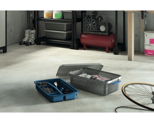 Scéna s regály, dílenským kompresorem, kbelíky s barvou, lyžařskými botami, kolem a dvěma úložnými boxy