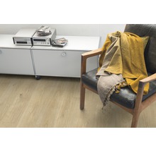 Obývací pokoj se světle hnědou laminátovou podlahou, křeslem a příborníkem