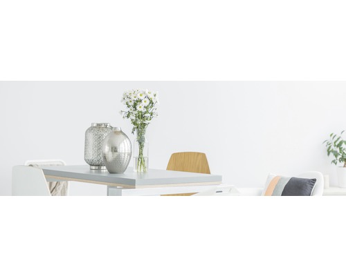 Světlá jídelna se stolem, židlemi, květinami a ozdobnými vázami