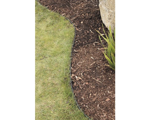 Obrubník odděluje trávník od mulče v zahradě