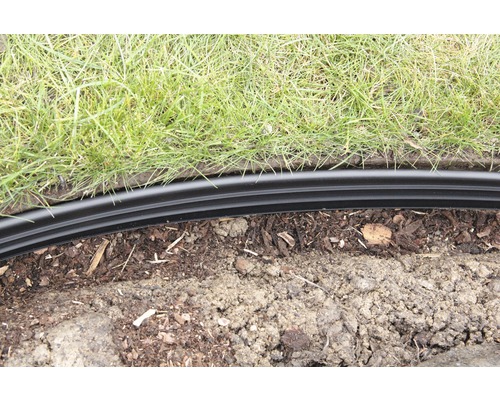 Zahradní scéna s trávníkem a černým okrajem trávníku