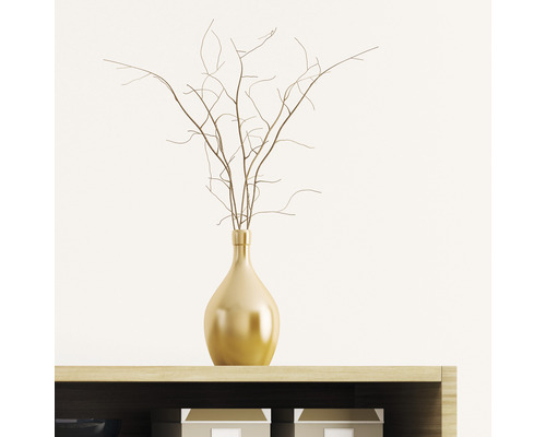 Dekorativní váza zlaté barvy s větvemi na polici.
