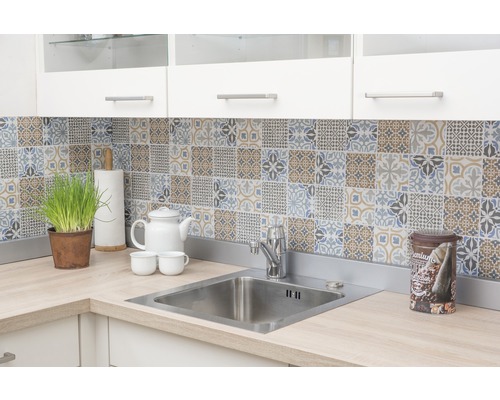 Kuchyňský dřez s vodovodní baterií a ozdobnými dlaždicemi na zdi