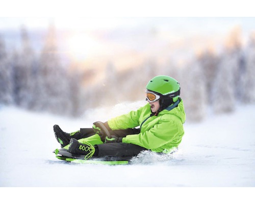 Chlapec sáňkuje na sněhu