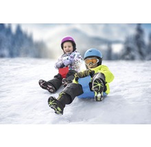 Dvě děti bobují na sněhu s mini bobem.