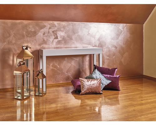 Interiér s dekorativní nástěnnou dekorací, bílý konzolový stolek, ozdobné polštáře a kovové lucerny na dřevěné podlaze