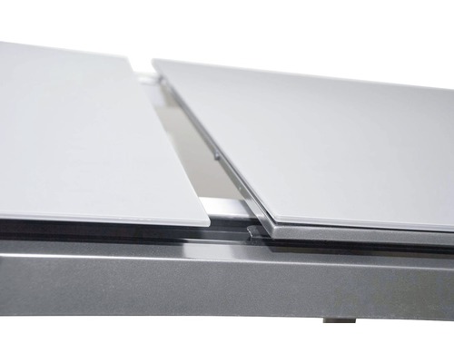 Detail výsuvného stolu s kovovým rámem a stolovými deskami