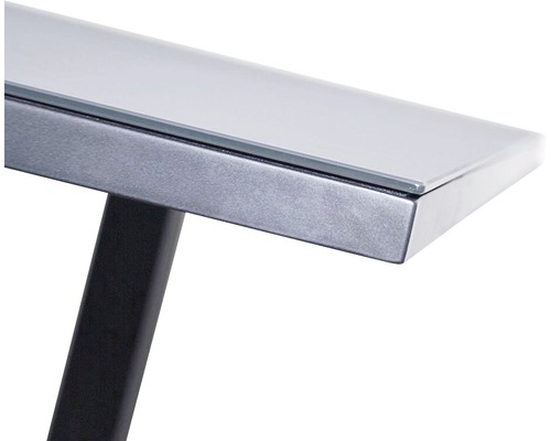 Detailní pohled na stolní desku se skleněnou deskou a kovovým rámem