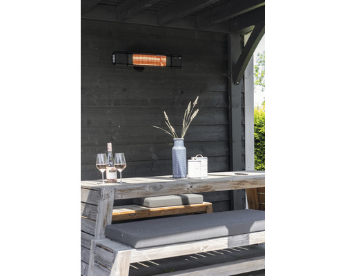 Terasa s terasovým ohřívačem, dřevěným stolem, lavicemi, dekorací a nápoji