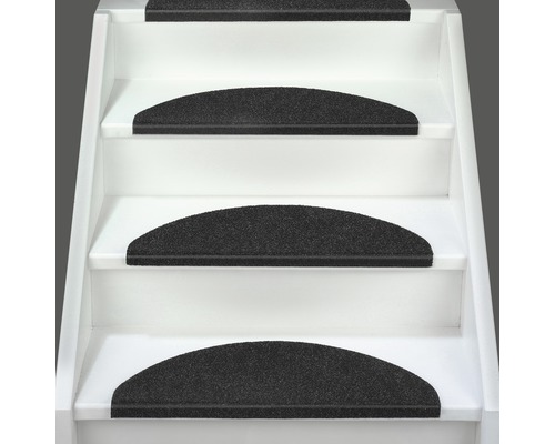 Schodiště s černými stupnicovými rohožemi pro snížení hluku a větší bezpečnost.