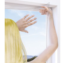 Osoba upevňuje síť proti hmyzu na okno